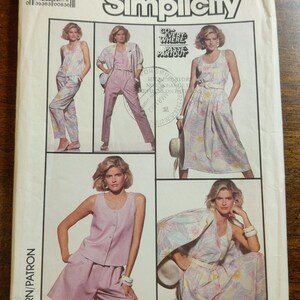 May include: Simplicity sewing pattern featuring various women's outfits. The pattern includes a jumpsuit, dress, shorts set, and a jacket with a floral print. The size is N (10+12+14). The pattern is for EUR sizes N(38+40+42).