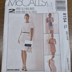 May include: McCall's sewing pattern for a 1 & 2 piece dress. The pattern features multiple dress styles, including a white dress with a black belt and a pink floral dress. The pattern size is AX (4,6,8).