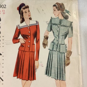 Op de afbeelding: Vintage naaipatroon voor een tweedelige jurk met een rok en een jasje. Het patroon toont twee vrouwen die de jurk dragen in rood en groen ruitjes. Het patroonnummer is 902.