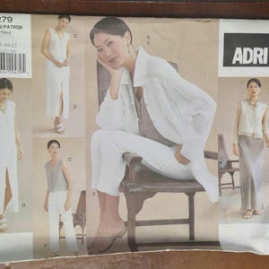 May include: A vintage sewing pattern titled "2279" by ADRI, featuring multiple images of a woman modeling various white outfits. The pattern includes a dress, pants, and a top. The size range is 8-10-12.