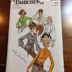 May include: Vintage sewing pattern for a blouse with a high collar and long sleeves. The pattern is from Butterick and is size 10, bust 32 1/2 inches. The pattern number is 5871 and the price is 85 cents. The pattern includes four different views of the blouse.