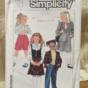 May include: A Simplicity 7060 sewing pattern envelope featuring illustrations of four children wearing various outfits including a blouse with red shorts, a plaid skirt with a ruffled collar, a blazer with a skirt, and a plaid blazer with blue pants.