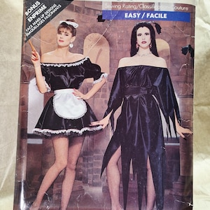 Peut inclure: Pochette de patron de couture Butterick 5800 présentant deux modèles de costumes. L'un est une robe noire à épaules dénudées avec un tablier blanc et une bordure en dentelle. L'autre est une robe noire à épaules dénudées avec des manches déchiquetées.