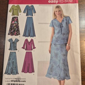Könnte beinhalten: Simplicity Schnittmuster zum einfachen Nähen, mit einer Frau in einem blauen Outfit mit Blumenmuster. Das Schnittmuster bietet Optionen für Oberteile und Röcke. Größen AA 10, 12, 14, 16, 18, EUR 36-44, FR 38-46. Besuchen Sie simplicify.com.