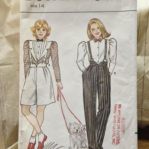 May include: A Butterick 4822 sewing pattern envelope, size 14, featuring illustrations of two outfits. One shows a white shirt with a grid-patterned jacket and shorts, the other a white shirt with pinstriped trousers and suspenders, plus a small dog.