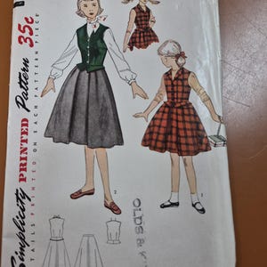 May include: Vintage Simplicity printed sewing pattern, size 10. The pattern features illustrations of a woman in a green vest and gray skirt, and a girl in a plaid dress. The price is 35 cents.