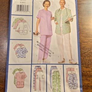 May include: Butterick Professional Uniform Basics sewing pattern 5710. The pattern features illustrations of medical scrubs in various colors and styles, including tops and pants. The size range is S-M-L. The text "FAST & EASY" is printed at the bottom.
