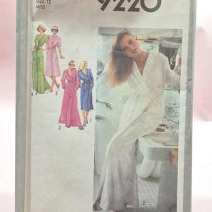 May include: Vintage Simplicity sewing pattern 9220, size 12 Miss. The pattern envelope features illustrations of women's robes in various colors, including green, pink, and blue. A woman in a white robe is also pictured. The envelope is slightly aged.