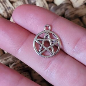 May include: Silver charm in the shape of a pentacle, a five-pointed star within a circle. The charm is a popular symbol in witchcraft and paganism.