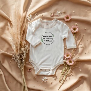 May include: White long-sleeve baby onesie with a green and black circle graphic that says "Leave me alone, I'm celebrating my Birthday!"