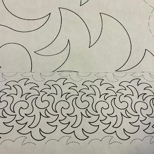 May include: A printed paper with black line art designs. The top portion features large, curved shapes, while the bottom has a repeating pattern of stylized waves. Dotted lines are also present, likely for quilting or sewing guidance.