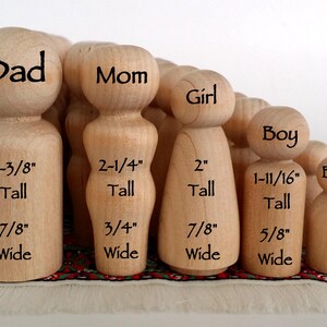 May include: A collection of unfinished light-colored wooden peg dolls in various sizes. Each figure is labeled with its role and dimensions in inches: Dad 2-3/8" tall, Mom 2-1/4" tall, Girl 2" tall, Boy 1-11/16" tall, and Baby 1-1/8" tall.