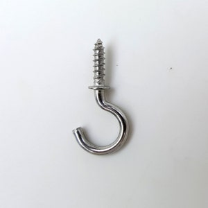May include: A silver screw-in hook with a rounded head and a sharp point. The hook is made of metal and has a shiny finish.