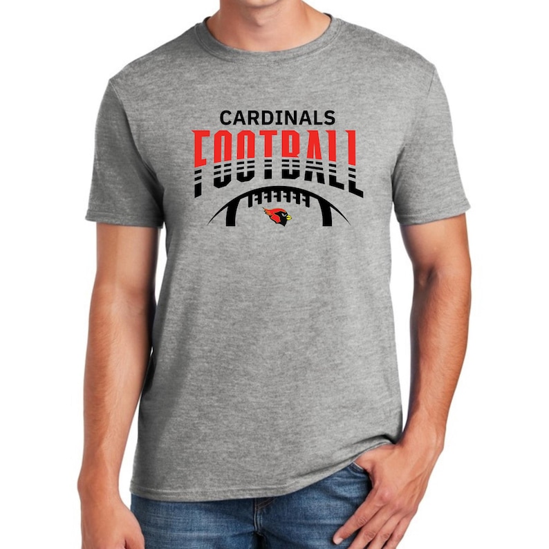Peut inclure: Un t-shirt gris avec un motif noir et rouge qui dit "CARDINALS FOOTBALL" avec un cardinal rouge et un motif de ballon de football.