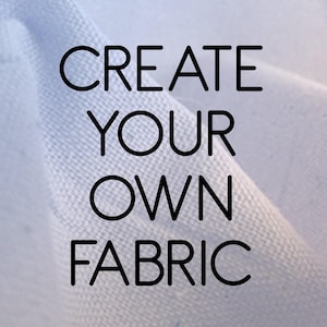May include: A close-up of light blue fabric with the text "CREATE YOUR OWN FABRIC" in black, bold letters. The fabric appears to be soft and textured, with subtle variations in color and tone.