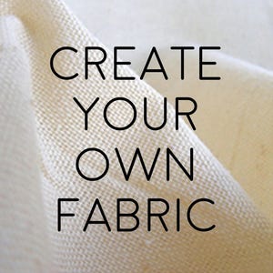 以下が含まれることがあります： クリーム色の生地のクローズアップ。黒字で「CREATE YOUR OWN FABRIC」と書かれています。生地は織られており、表面にテクスチャがあり、折り目が影を作っています。