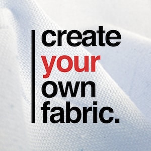 以下が含まれることがあります： 画像には、白い生地の背景に、黒と赤のフォントで「create your own fabric.」というテキストが表示されています。 生地は軽くて質感のある素材のようです。 テキストは画像の左側に縦に配置されています。