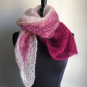 May include: A soft, pink and white ombre knitted scarf with a fuzzy texture.