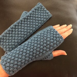 Peut inclure: Une paire de mitaines bleu crochetées. Les mitaines ont un motif de point texturé.