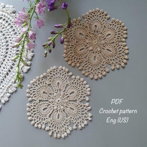 Puede incluir: Dos manteles individuales de ganchillo beige con intrincados patrones. Los manteles individuales están sobre una superficie gris. El texto "PDF Crochet pattern Eng (US)" está en la esquina inferior derecha de la imagen.