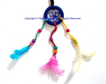 May include: A dreamcatcher keyring with a blue felt ring and a webbed centre. It features colourful feathers in blue, pink, and yellow, along with beads in various colours. The keyring has a silver ring.