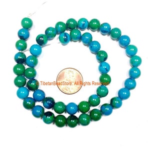 May include: A strand of green and blue gemstone beads, approximately 8mm in diameter. The beads are round and have a smooth, polished finish. The beads are strung on a clear thread and are displayed against a white background. &copy;TibetanBeadStore. All Rights Reserved.