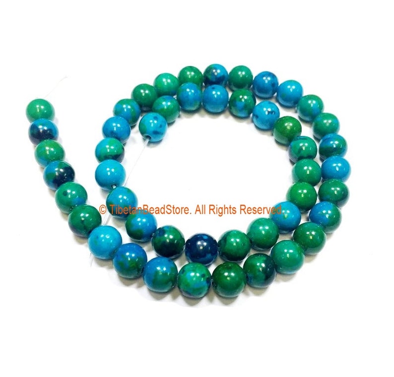 May include: A strand of round, green and blue gemstone beads. The beads are approximately 6mm in diameter and have a smooth, polished finish.