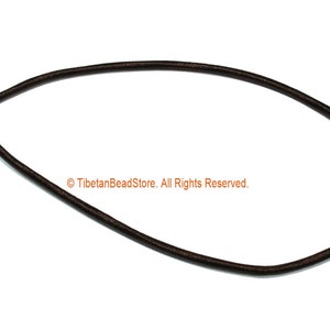 May include: A dark brown cord necklace with a knotted closure. The cord is circular and appears to be made of a flexible material. The text "© TibetanBeadStore. All Rights Reserved." is visible.