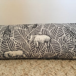 May include: Grey and white fabric with a leaf design and black and white drawings of giraffes, rhinos, and zebras. The fabric is suitable for home decor or craft projects.