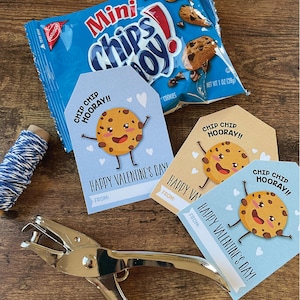 May include: Three Valentine's Day gift tags featuring a cartoon chocolate chip cookie with the text "Chip Chip Hooray!" and "Happy Valentine's Day!"  The tags are blue, light brown, and beige.