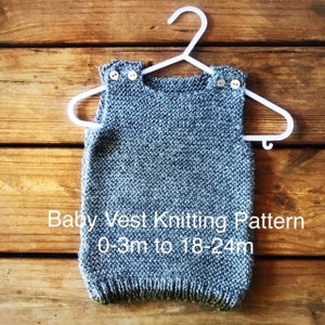 May include: A grey knitted baby vest with white buttons, hanging on a white hanger. The vest is for babies 0-3 months to 18-24 months. Baby Vest Knitting Pattern 0-3m to 18-24m