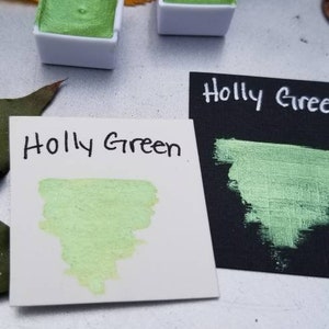 May include: Two small pans of metallic green watercolor paint, labeled "Holly Green", with a sample of the paint on a white card.