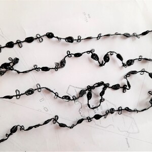 May include: Black crocheted trim with small loops and a delicate design.