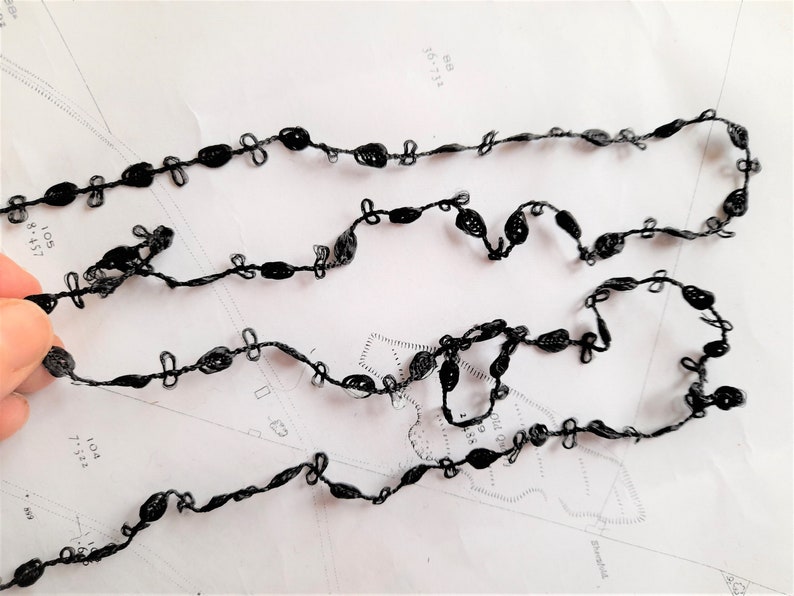 May include: Black crocheted trim with small loops and a delicate design.