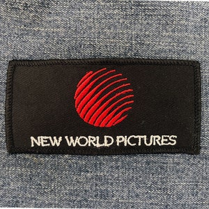 May include: Black patch with a red circle and white text that reads "NEW WORLD PICTURES".