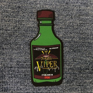 May include: A green glass bottle with a red cap and a black label. The label says "Tenafiy Viper" and "30 Proof".