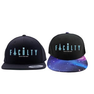 Op de afbeelding: Twee zwarte petten met platte klep met het woord "FACULTY" in lichtblauw en de tekst "THE IS IN YOUR FUTURE". Eén pet heeft een klep met galaxiethema. De petten zijn een modeaccessoire.