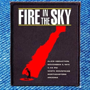 May include: A black patch with the text "FIRE IN THE SKY" in white and yellow. Below the text is a red graphic and the words "ALIEN ABDUCTION NOVEMBER 5, 1975 5:48 PM WHITE MOUNTAINS NORTHEASTERN ARIZONA."