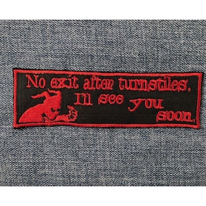 May include: A black rectangular patch with red embroidered text and a red graphic. The text reads "No exit after turnstiles. I'll see you soon." The graphic is a stylized red devil figure. The patch is on a blue denim background.