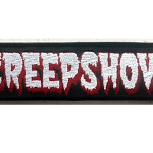 Peut inclure: Écusson brodé noir avec le mot "CREEP SHOW" en lettres blanches avec un contour rouge.