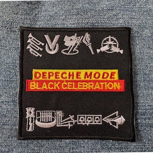 May include: Black embroidered patch featuring the text "DEPECHE MODE BLACK CELEBRATION" in yellow and red. The patch has various embroidered symbols in white. The patch is square and set against a denim background.