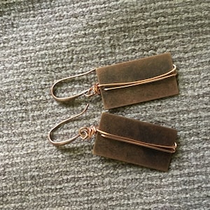 May include: A pair of copper earrings with rectangular copper plates and wire accents.