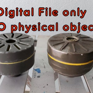 Op de afbeelding: Twee ronde, grijze, metalen gasmaskerfilters met een gele streep rond het midden. De tekst "Digitaal bestand alleen GEEN fysiek object" wordt boven de filters weergegeven.