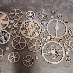 May include: A set of wooden gears in various sizes and shapes, arranged in a circular pattern on a grey background. The gears are all made of light brown wood and have intricate designs.