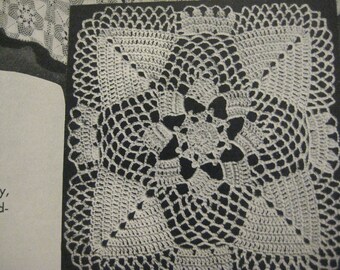 May include: A white crocheted doily with a square shape and a detailed floral design in the center.