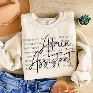 Op de afbeelding: Crèmekleurige sweatshirt met de woorden "Admin Assistant" in een stijlvol lettertype. De sweatshirt heeft een lijst met positieve eigenschappen zoals "Georganiseerd", "Efficiënt" en "Betrouwbaar". De sweatshirt wordt gecombineerd met een blauwe spijkerbroek en sandalen.