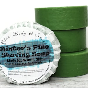 May include: A stack of three green shaving soap bars next to a wrapped bar. The wrapped bar has a label that reads "Winter's Pine Shaving Soap" and "Made for Winter Skin." The wrapped bar is 4.5 oz / 128g.