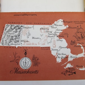 May include: A vintage map of Massachusetts with the state's major cities and towns labeled. The map is printed on a red background with black text and illustrations. The map includes a small illustration of the Mayflower ship and a seal of the state of Massachusetts.