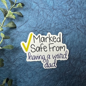 May include: White sticker with a yellow checkmark and the text "Marked Safe From having a weird dad".