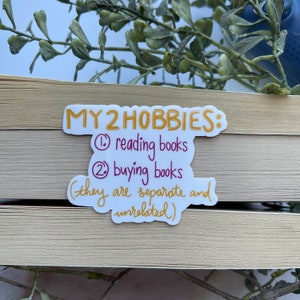 May include: A yellow sticker with the text "MY 2 HOBBIES: 1. reading books 2. buying books (they are separate and unrelated)"